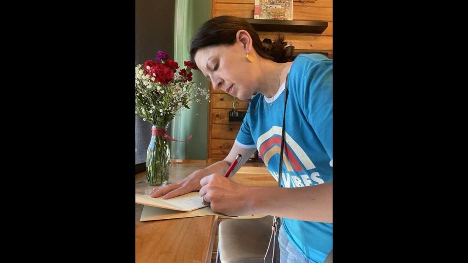 Stephanie Thoms of Fairway, Kansas, writes “Thinking of you” in a letter expressing her condolences for the loss of Fairway Police Officer Jonah Oswald at the local Front Range coffee shop on Tuesday afternoon.