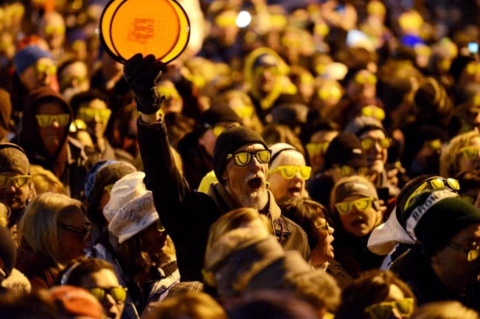 Crowds brave the cold to break the current Guinness World Record for people wearing sunglasses in the dark for the fourth annual Laughfest Kickoff at Rosa Parks Circle in downtown Grand Rapids, Mich., on Thursday, March 6, 2014. The current record was set at Wrigley Field in Chicago in July 2012 with 1,642 people. (AP Photo/MLive.com, Emily Rose Bennett)