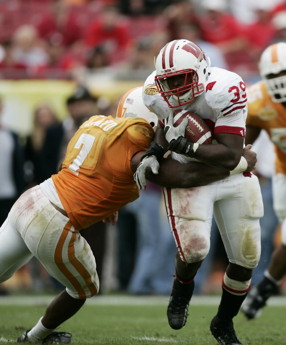 Jan 1, 2008; Tampa, FL, USA; Wisconsin Badgers running back P.J. Hill (39) carries the ball as Tennessee Volunteers linebacker Jerod Mayo (7) attempts to make the tackle during the second half during the Outback Bowl at Raymond James Stadium. Tennessee won the game 21-17. Mandatory Credit: James Lang-USA TODAY Sports