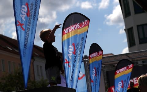A child stands by flags during an Alternative for Germany (AfD) campaign event in Prenzlau, Germany, on Saturday, Aug. 3, 2019. - Credit: Krisztian Bocsi/Bloomberg