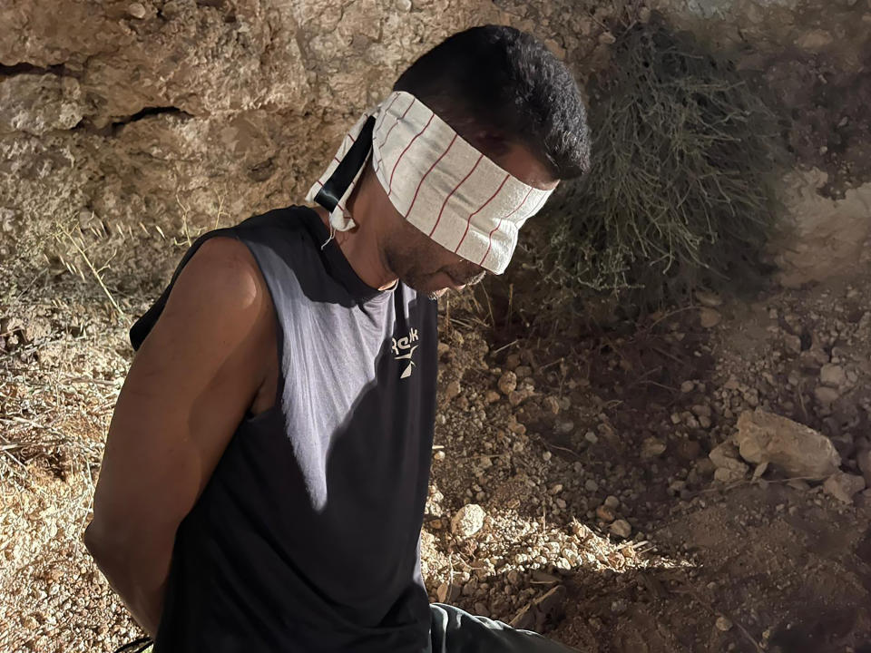 In this photo provided by Israel Police, Zakaria Zubeidi, one of the six Palestinians who escaped from a high-security prison earlier this week, is blindfolded after being recaptured in the Arab town of Umm al-Ghanam, northern Israel, Saturday, Sept. 11, 2021. Israeli police on Saturday said they have arrested four of the six Palestinians who broke out of a maximum-security prison this week including Zubeidi, a famed militant leader whose exploits over the years have made him a well-known figure in Israel. (Israeli Police via AP)