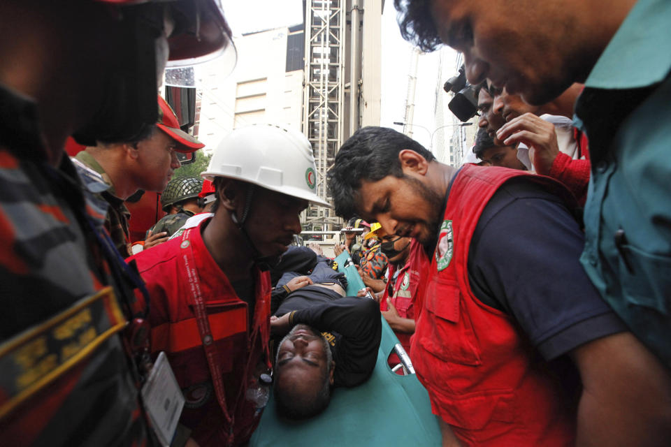 Firefighters evacuate an injured after a multi-storied office building caught fire in Dhaka, Bangladesh, March 28, 2019.  (AP Photo/Mahmud Hossain Opu )