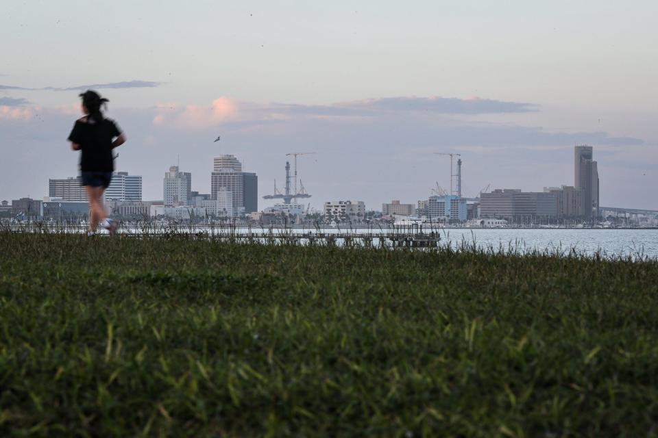 A runner jogs along a path in Cole Park overlooking Downtown Corpus Christi on Dec. 15, 2023, in Texas.