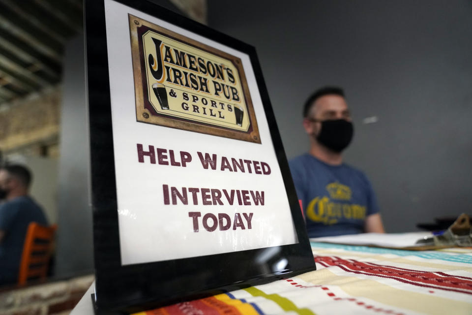 FILE - A hiring sign is placed at a booth for Jameson's Irish Pub during a job fair Wednesday, Sept. 22, 2021, in the West Hollywood section of Los Angeles. The number of Americans applying for unemployment benefits plunged last week, Dec. 9, to the lowest level in 52 years, more evidence that the U.S. job market is recovering from last year’s coronavirus recession. (AP Photo/Marcio Jose Sanchez, File)