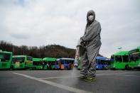 An employee from a disinfection service company sanitizes the floor of a bus garage in Seoul