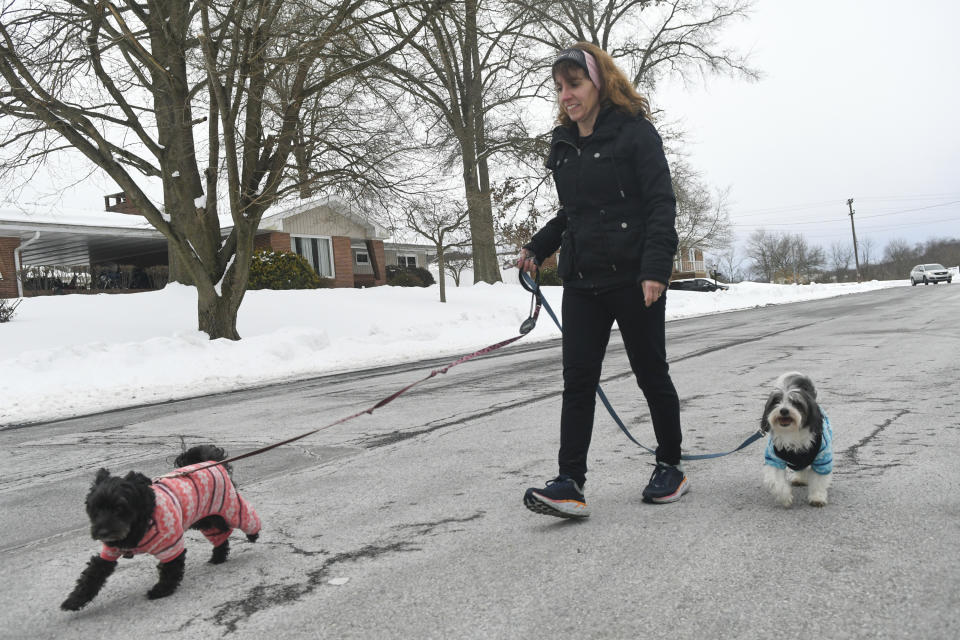 Lisa Haas, of Orwigsburg, Pa., walks her dogs Maggie, left, and Charlie, right, along Washington Street as her daughter Olivia Haas goes for a run around Stoyer's Dam in Schuylkill Haven, Pa., on Friday afternoon, Feb. 12, 2021. (Jacqueline Dormer/Republican-Herald via AP)