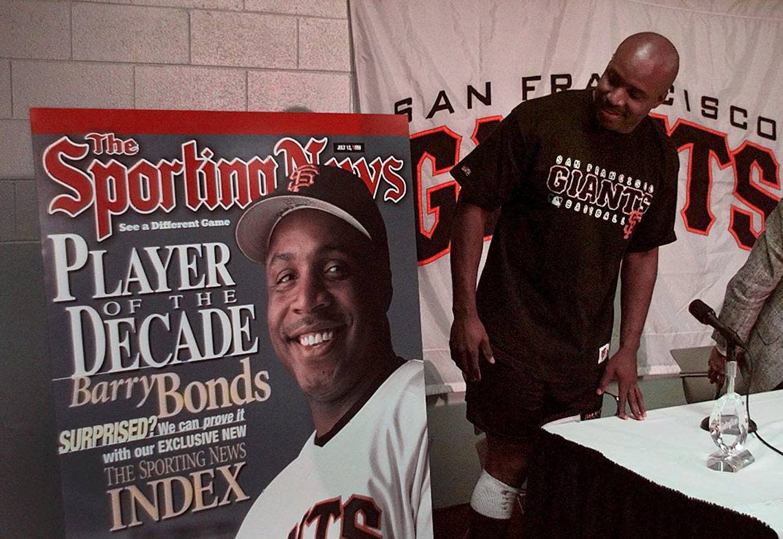 ** FILE ** San Francisco Giants’ left fielder Barry Bonds looks at his image on an enlarged cover of The Sporting News prior to a news conference in this July 9, 1999 file photo, in San Francisco. The Sporting News named Bonds their “Player of the Decade” for the 1990’s. (AP Photo/Ben Margot)