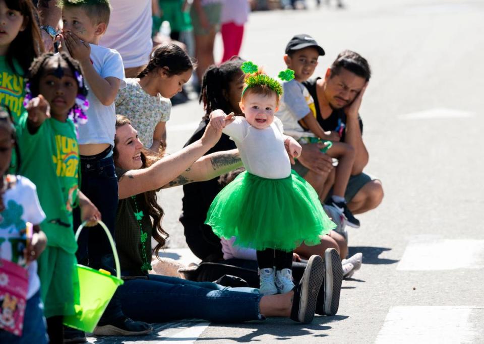 Juniper Vengelen, 1, is held by her mom Tiffany as she and other families watch the annual St. Patrick’s Day parade in Old Sacramento on Saturday, March 16, 2024.