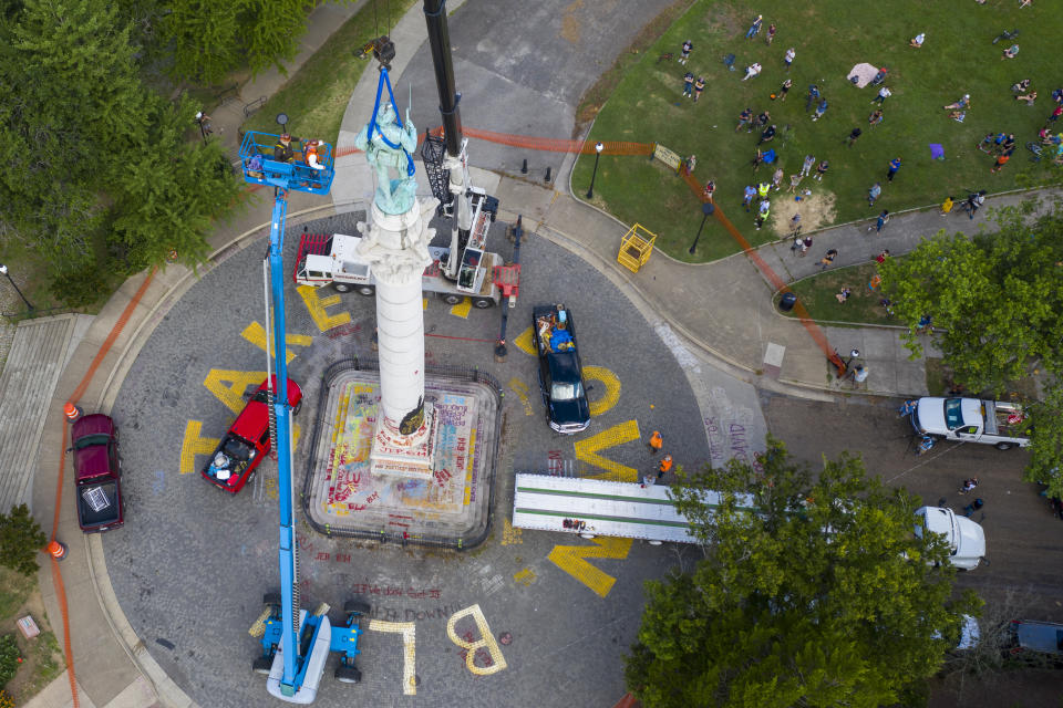 Crews work to remove the Confederate Soldiers & Sailors Monument in Libby Hill Park, Wednesday, July 8, 2020, in Richmond, Va. The 17 ft statue stands on a 73 foot pedestal overlooking downtown. The statue is one of several that will be removed by the city as part of the Black Lives Matter reaction. (AP Photo/Steve Helber)
