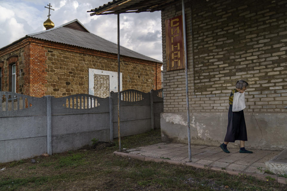 An elderly resident arrives to buy bread from a shop before it opens in Ivanopillia, Donetsk region, eastern Ukraine, Saturday, Aug. 20, 2022. "People's income has decreased, and people are just buying cheaper products at the moment," says Oleksandr Milov, director of the nearby bakery. His bakers have even had to change the recipe of their bread to keep the price affordable as long as possible. (AP Photo/David Goldman)