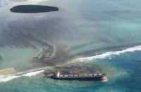 This photo taken and provided by Eric Villars shows oil leaking from the MV Wakashio, a bulk carrier ship that recently ran aground off the southeast coast of Mauritius, Friday, Aug. 7, 2020. Anxious residents of the Indian Ocean island nation of Mauritius are stuffing fabric sacks with sugar cane leaves to create makeshift oil spill barriers as tons of fuel leak from a grounded ship. The government has declared an environmental emergency and France says it is sending help from its nearby Reunion island. (Eric Villars via AP)