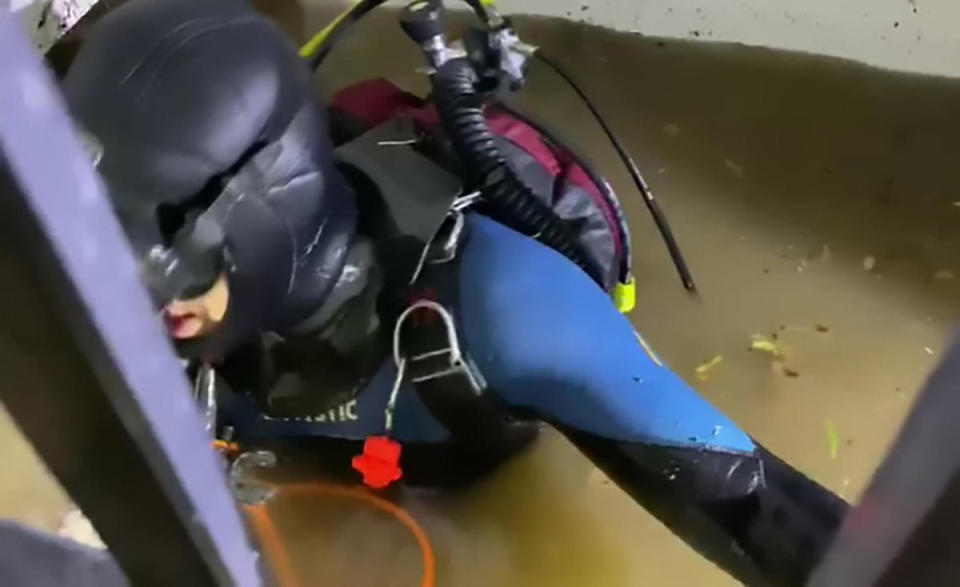 A scuba diver is pictured in a flooded lift shaft.