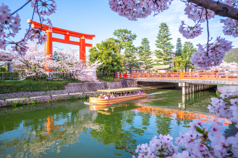 Kyoto, Japan - April 5, 2016: Heian Jingu's Torii and Okazaki Canal with cherry blossom. Okazaki Canal connects the Lake Biwa Canal network with Kamo River
