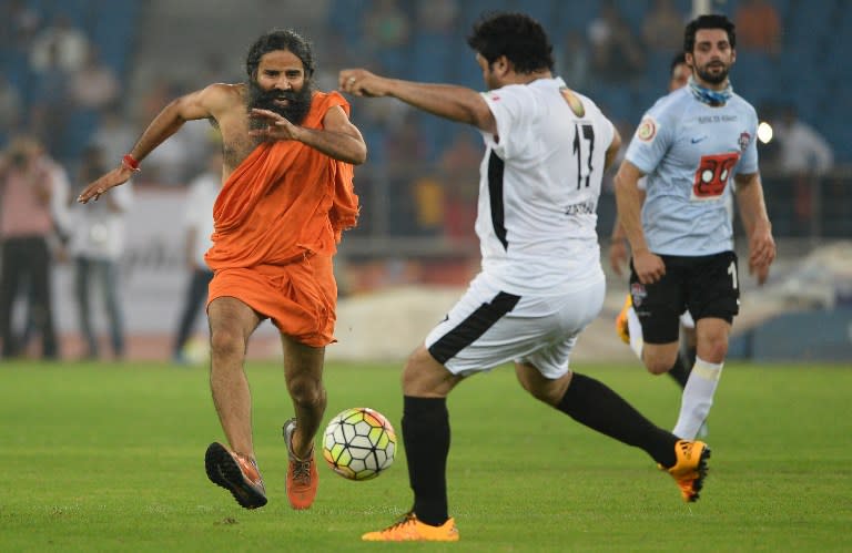 <p>Indian yoga guru Baba Ramdev (L) and members of the Indian Parliamentarian team play during a charitable football match between Indian Bollywood actors and Indian Parliamentarians in New Delhi on July 24, 2016. The football match is an attempt to raise awarness for two flagship initiatives by Prime Minister Narender Modi, the ‘Clean India’ campaign and a female empowerment programme. </p>