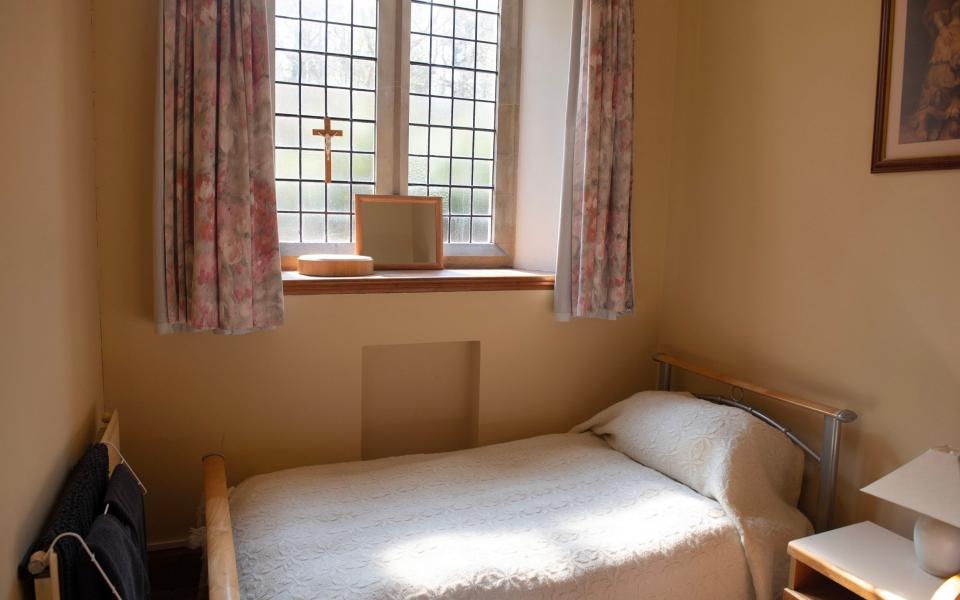 A small bed in a small room with light shining through the window - BNPS