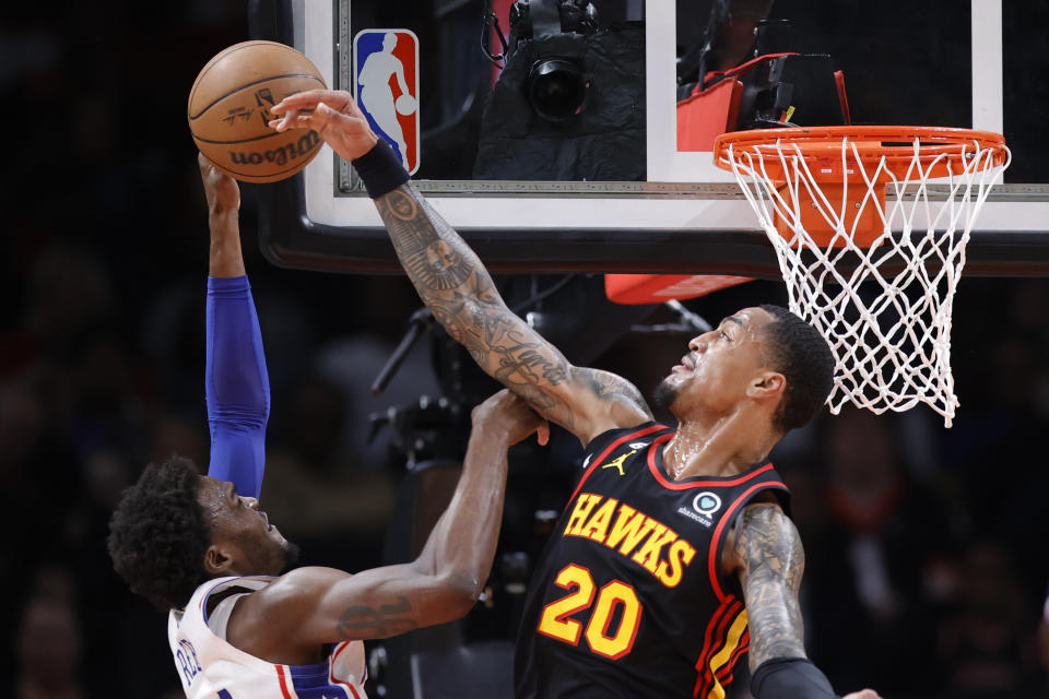 Atlanta Hawks forward John Collins, right, blocks a shot from Philadelphia 76ers forward Paul Reed during the first half of an NBA basketball game Friday, April 7, 2023, in Atlanta. (AP Photo/Alex Slitz)