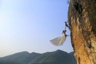 RNPS - REUTERS NEWS PICTURE SERVICE - PICTURES OF THE YEAR 2014 - ODDLY Zheng Feng, an amateur climber takes wedding pictures with his bride on a cliff in Jinhua, Zhejiang province, in this October 26, 2014 file photo. REUTERS/China Daily/Files (CHINA - Tags: SOCIETY TPX IMAGES OF THE DAY) CHINA OUT. NO COMMERCIAL OR EDITORIAL SALES IN CHINA