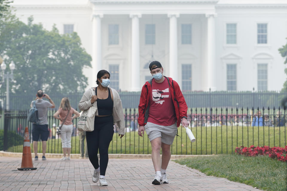 People walk near the White House in Washington, Thursday, June 8, 2023, as smoke from Canadian wildfires obscures the view. Intense Canadian wildfires are blanketing the northeastern U.S. in a dystopian haze, turning the air acrid, the sky yellowish gray and prompting warnings for vulnerable populations to stay inside. (AP Photo/Susan Walsh)