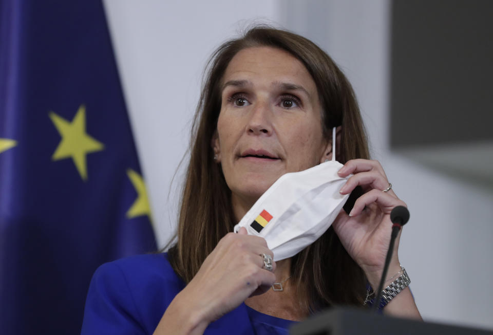 Belgian Prime Minister Sophie Wilmes takes off her protective mask prior to a press conference following the National Security Council meeting on the COVID-19 outbreak, in Brussels, Wednesday, Sept. 23, 2020. Belgium's prime minister announced Wednesday a relaxation of social-distancing rules as part of a less stringent long-term coronavirus strategy, despite the steady rise of COVID-19 cases in a country already hard-hit by the virus. (Olivier Hoslet, Pool via AP)