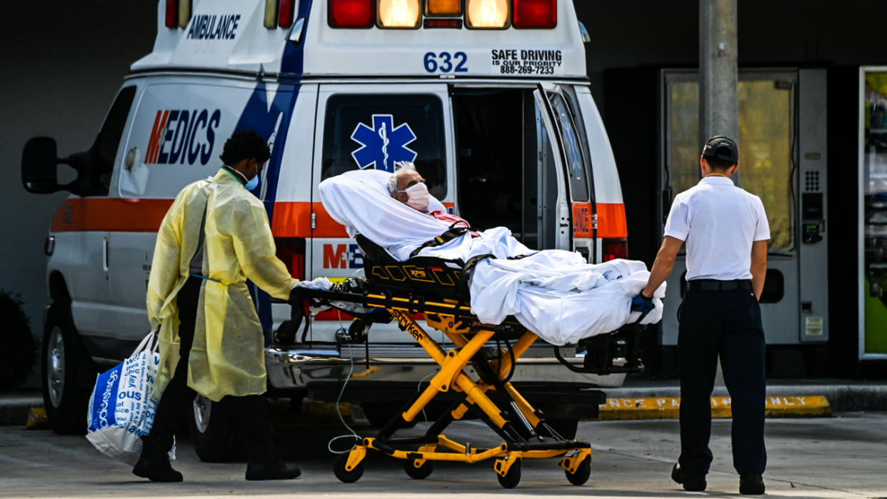 Medics transfer a patient on a stretcher from an ambulance outside of Emergency at Coral Gables Hospital where Coronavirus patients are treated in Coral Gables near Miami, on August 16, 2021. (Chandan Khanna/AFP via Getty Images)
