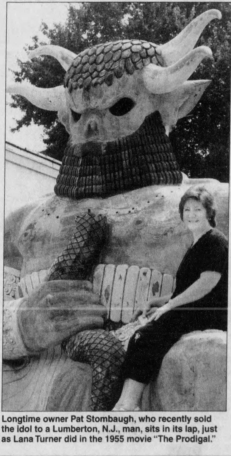 In this July 21, 2004, photo, Pat Stombach sits in the lap of a Hollywood movie prop statue that for years sat outside her travel agency on U.S. 13 across the Smyrna rest stop. The statue appeared in the movie "The Prodigal" starring Lana Turner.