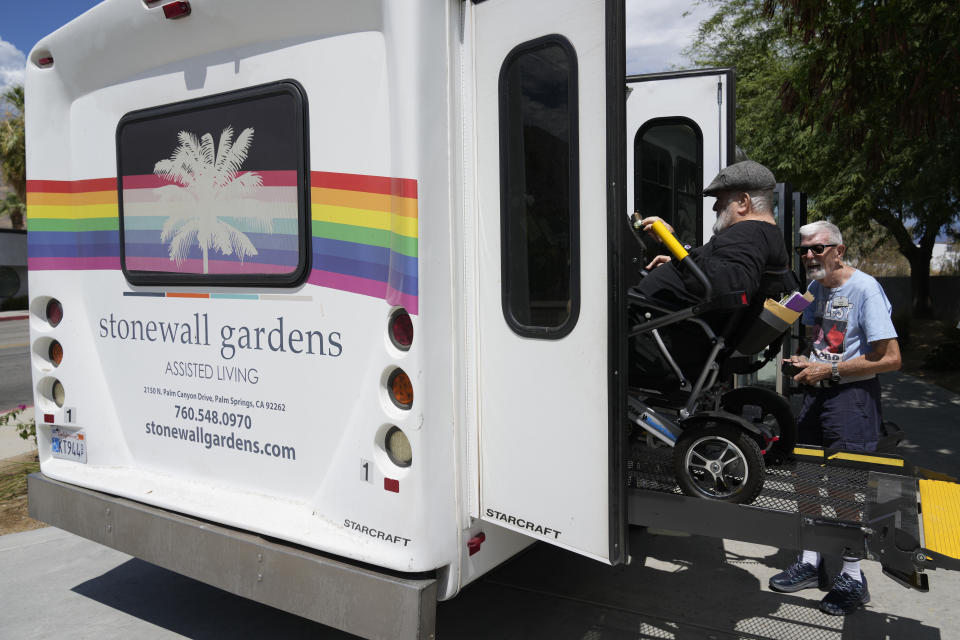 Resident Billy Church, in wheelchair, is helped into a van headed for a group lunch at Stonewall Gardens, a LGBTQ+ assisted living facility, Tuesday, Aug. 15, 2023, in Palm Springs, Calif. About 171,000 of the more than 1.3 million transgender adults in the United States are aged 65 and older, according to numbers compiled by the Williams Institute at the UCLA School of Law. (AP Photo/Marcio Jose Sanchez)