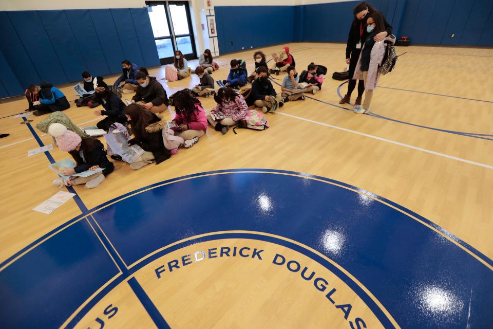 A teacher embraces a new student while waiting in the gymnasium for the first day of school at the new Alma del Mar Frederick Douglass campus on Church Street in New Bedford.