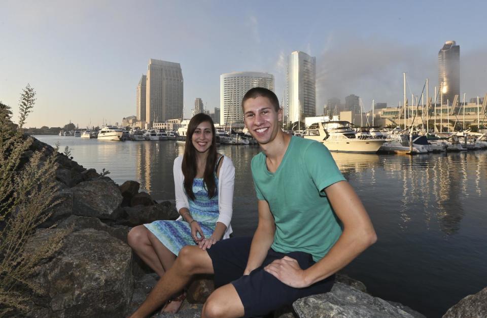 In this Tuesday, Oct. 15, 2013, photo, Melissa Grothues and her fiance John Steele pose at a spot on San Diego Bay in San Diego. The couple left the Buffalo, New York suburb of Amherst seeking a new life with a new environment and landed in San Diego. (AP Photo/Lenny Ignelzi)