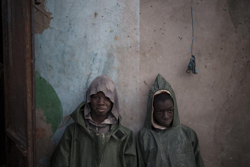 Two young fishermen from Senegal lean on a wall after returning from a fishing expedition in Nouadhibou, Mauritania, Wednesday, Dec. 1, 2021. (AP Photo/Felipe Dana)