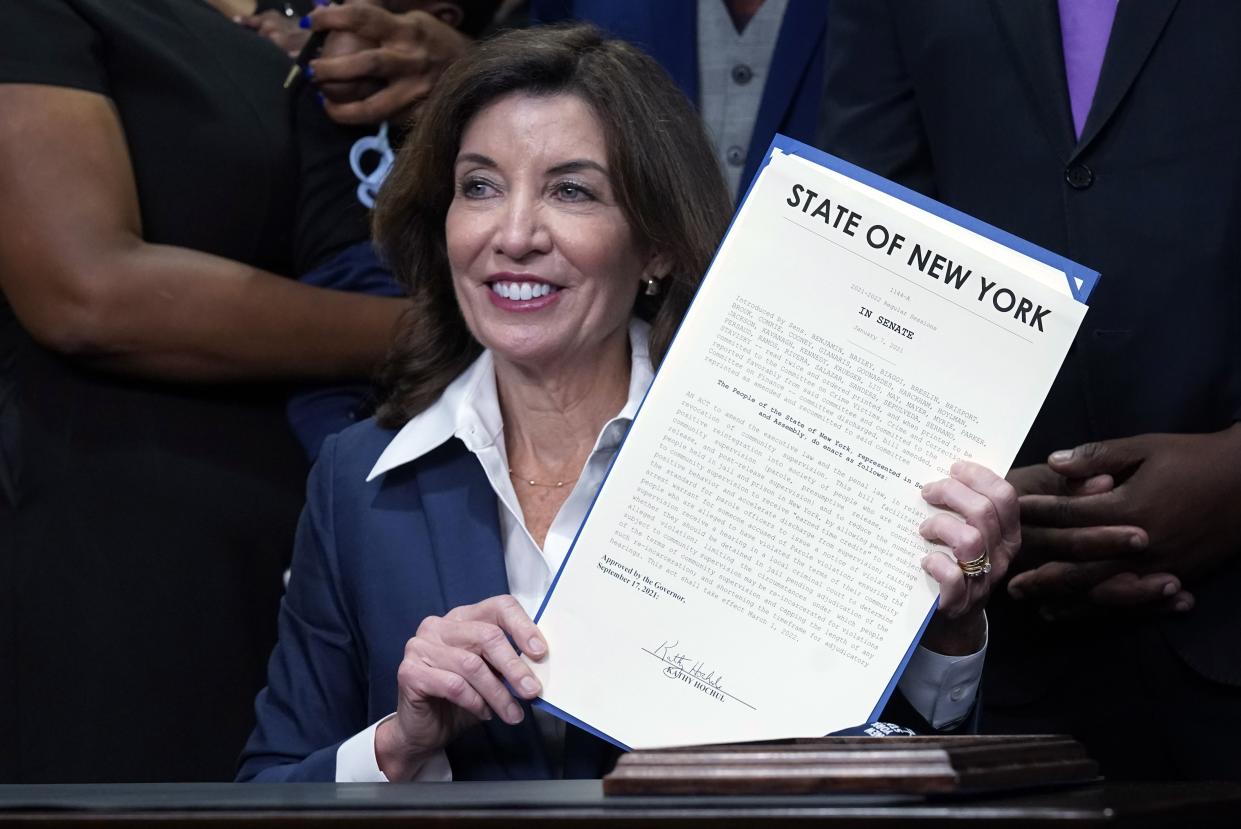 New York Gov. Kathy Hochul holds the "Less is More" law she signed, during ceremonies in the her office, in New York, Friday, Sept. 17. 