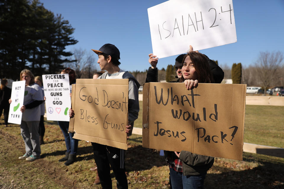 <p>Anti-gun protesters stand outside as couples with AR-15 rifles and other guns participate in a ceremony at the World Peace and Unification Sanctuary in Newfoundland, Pennsylvania on February 28, 2018 in Newfoundland, Pennsylvania. (Photo: Spencer Platt/Getty Images) </p>