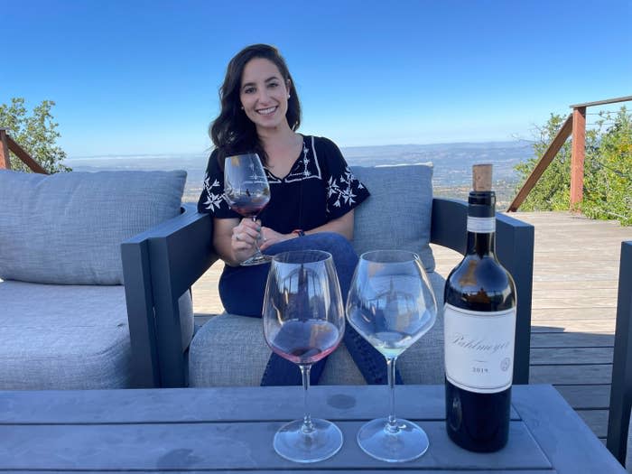 Warner sitting on a sunny patio with a glass of wine