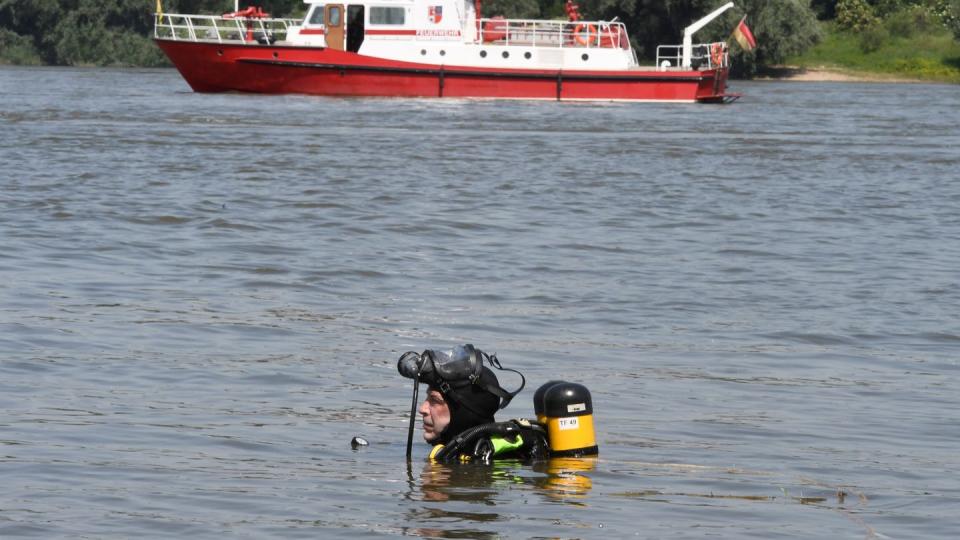 Nachdem es am Mittwoch am Rhein bei Duisburg zu einem Badeunfall gekommen war, suchte dieser Taucher der Feuerwehr nach den vermissten Mädchen. Nun sind in den Niederlanden zwei Leichen entdeckt worden.