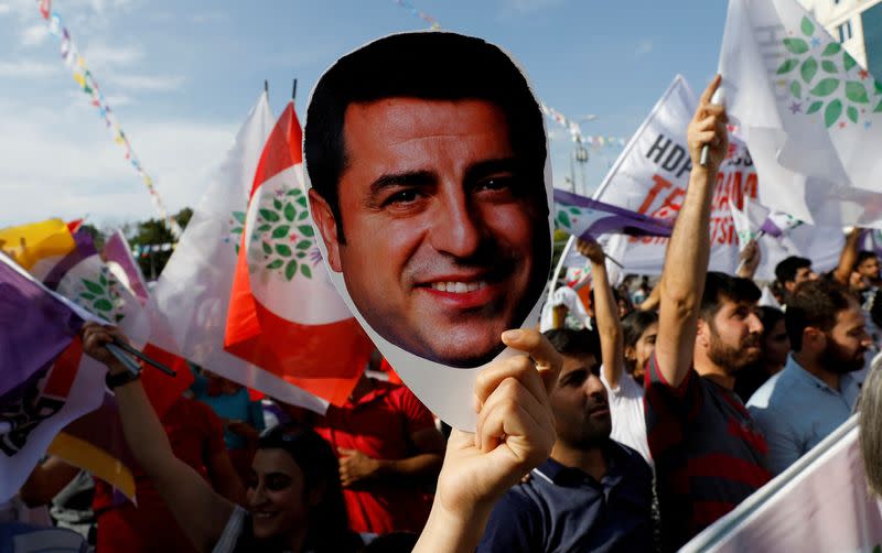 FILE PHOTO: A supporter of Turkey's main pro-Kurdish Peoples' Democratic Party holds a mask of their jailed former leader and presidential candidate Selahattin Demirtas during a rally in Ankara