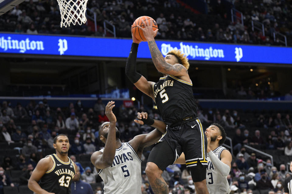 Villanova guard Justin Moore, right center, goes to the basket against Georgetown center Timothy Ighoefe, left center, during the first half of an NCAA college basketball game, Saturday, Jan. 22, 2022, in Washington. (AP Photo/Nick Wass)