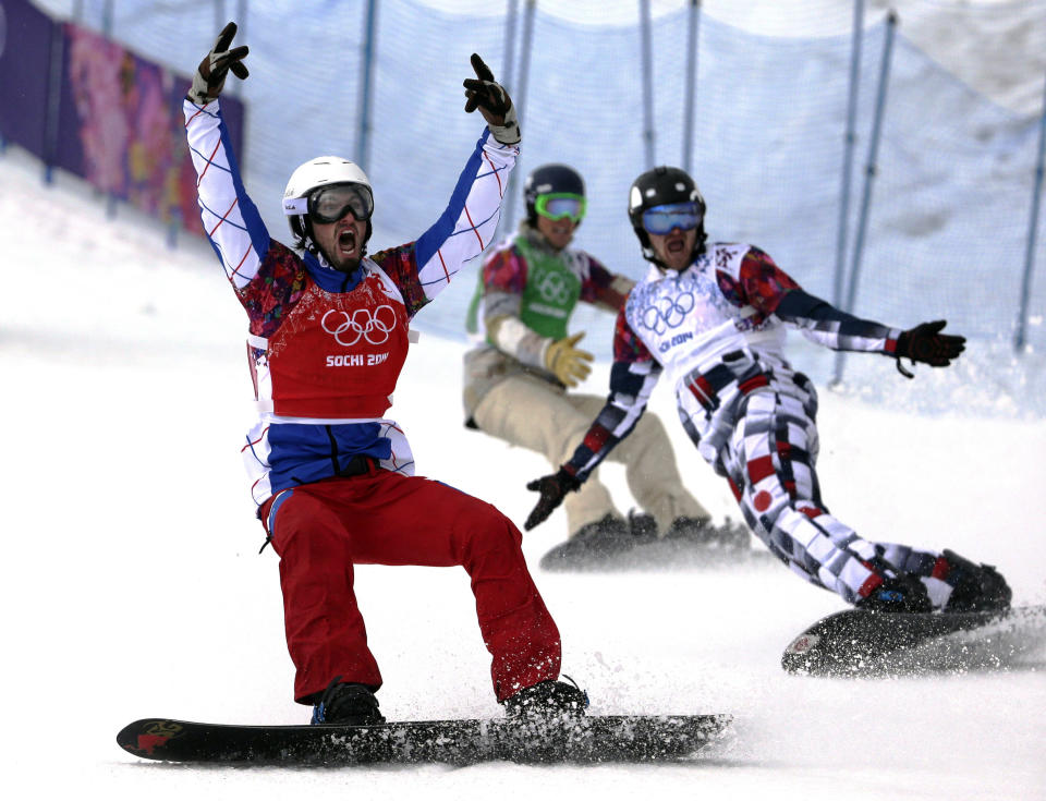 France's Pierre Vaultier, left, celebrates taking the gold medal ahead of silver medalist Nikolai Olyunin of Russia, right, and bronze medalist Alex Deibold of the United States, in the men's snowboard cross final at the Rosa Khutor Extreme Park, at the 2014 Winter Olympics, Tuesday, Feb. 18, 2014, in Krasnaya Polyana, Russia. 