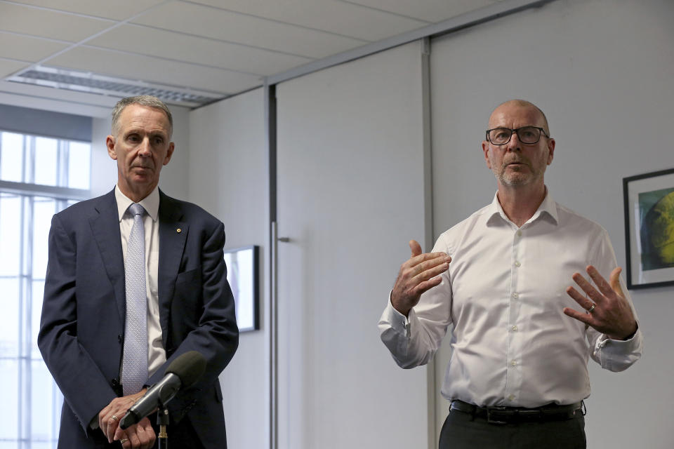 Group Executive Corporate Affairs Policy and Government Relations at News Corp Australia, Campbell Reid, left, listens as Chief Executive Officer of Australian Associated Press (AAP) Bruce Davidson speaks during a closure announcement at the AAP head office in Sydney, Tuesday, March 3, 2020. National news agency Australian Associated Press said Tuesday it was closing after 85 years, blaming a decline in subscribers and free distribution of news content on digital platforms. (Dylan Coker/AAP Images via AP)