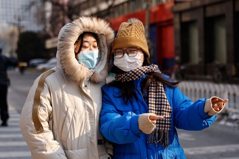 People walk on a street on a cold winter day in Beijing