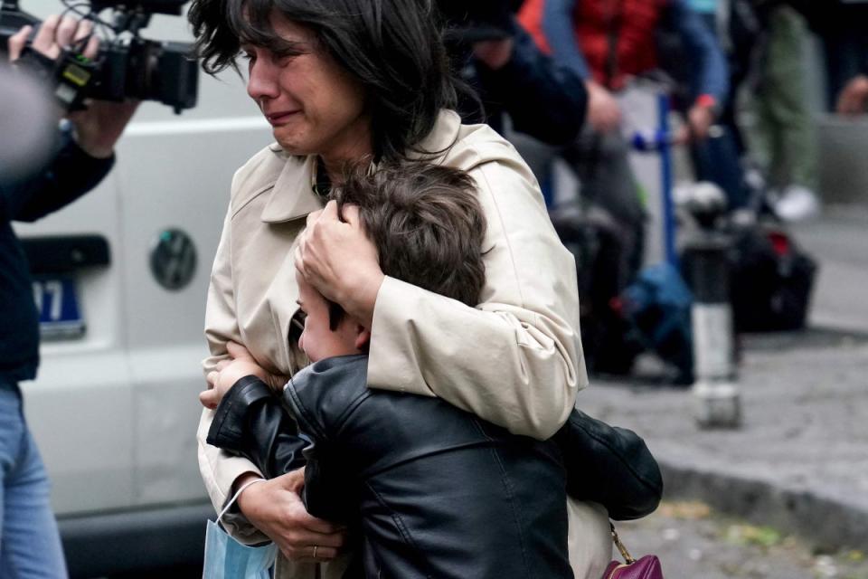 A parent escorts her child following a shooting at a school in the capital Belgrade (AFP via Getty Images)
