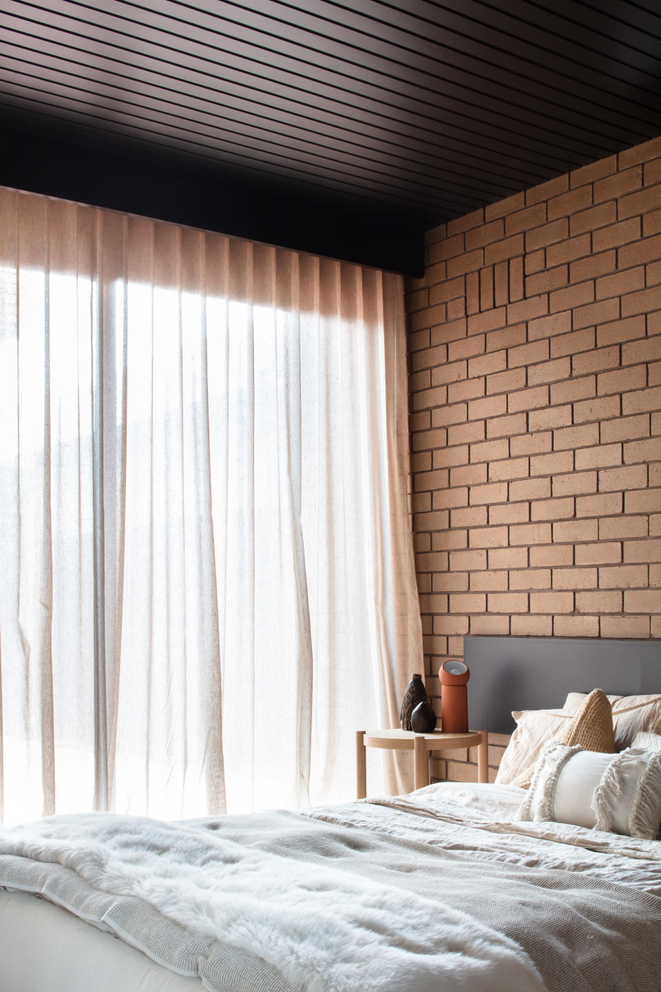 A bedroom with a brick wall