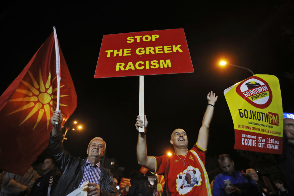 Supporters of a movement for voters to boycott the referendum, holding placards and national flags chant slogans as they celebrate in central Skopje, Macedonia, after election officials gave low turnout figures, Sunday, Sept. 30, 2018. The crucial referendum on accepting a deal with Greece to change the country's name to North Macedonia to pave the way for NATO membership attracted tepid voter participation Sunday, a blow to Prime Minister Zoran Zaev's hopes for a strong message of support. (AP Photo/Thanassis Stavrakis)