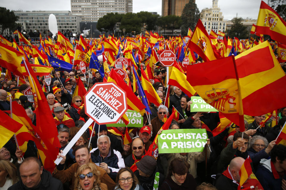 Demonstrators hold banners and Spanish flags during a protest in Madrid, Spain, on Sunday, Feb.10, 2019. Thousands of Spaniards in Madrid are joining a rally called by right-wing political parties to demand that Socialist Prime Minister Pedro Sanchez step down. Banner reads in Spanish "coup leaders must go to the prison". (AP Photo/Andrea Comas)