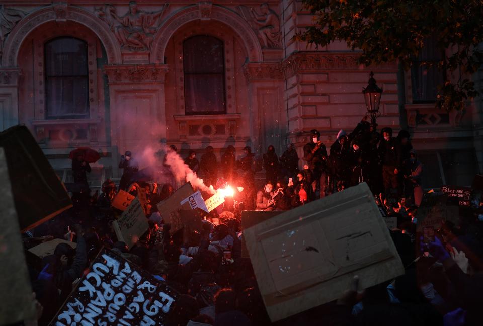 Protesters holding placards light a flare during an anti-racism demonstration on Whitehall, near the entrance to Downing Street in central London on June 6, 2020, to show solidarity with the Black Lives Matter movement in the wake of the killing of George Floyd, an unarmed black man who died after a police officer knelt on his neck in Minneapolis. - The United States braced Friday for massive weekend protests against racism and police brutality, as outrage soared over the latest law enforcement abuses against demonstrators that were caught on camera. With protests over last week's police killing of George Floyd, an unarmed black man, surging into a second weekend, President Donald Trump sparked fresh controversy by saying it was a "great day" for Floyd. (Photo by DANIEL LEAL-OLIVAS / AFP) (Photo by DANIEL LEAL-OLIVAS/AFP via Getty Images)