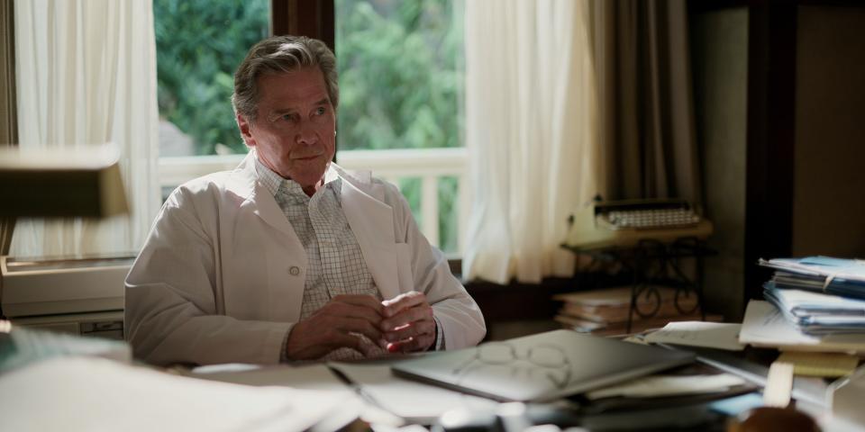 Doc Mullins sitting at a table filled with paperwork.