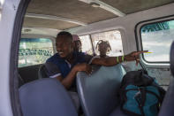 Jhon Celestin, his wife Delta De Leon and their daughter Chloe, deported from the United States a few days earlier, sit in a minibus, in Port-au-Prince, Haiti, Friday, Sept. 24, 2021. On their second day in Haiti, the couple decided to travel to Jacmel to visit relatives, a risky trip because it entails crossing gang-controlled territory. Buses often form convoys for safety, and sometimes pay gangs for safe passage. (AP Photo/Joseph Odelyn)