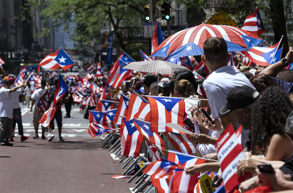 Spectators hold hundreds of flags of Puerto Rico as they watch the National Puerto Rican Day Parade Sunday, June 9, 2019, in New York. (AP Photo/Craig Ruttle)