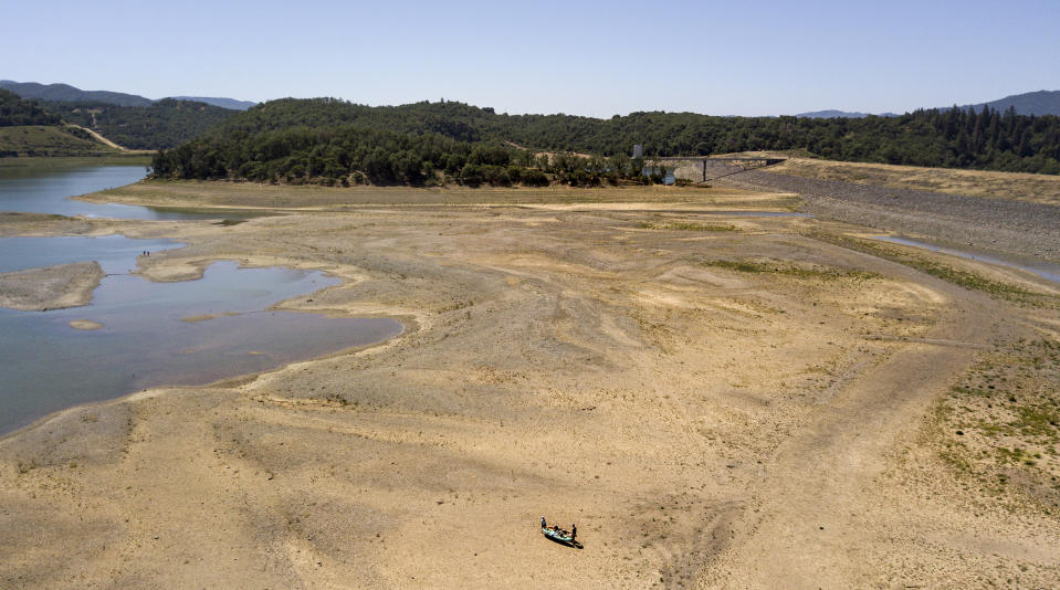 Kayakers make a long trek to the water's edge at a drought-stricken Lake Mendocino, currently at 29% of normal capacity, in Ukiah, Calif., Sunday, May 23, 2021. California Gov. Gavin Newsom declared a drought emergency for most of the state. (AP Photo/Josh Edelson)