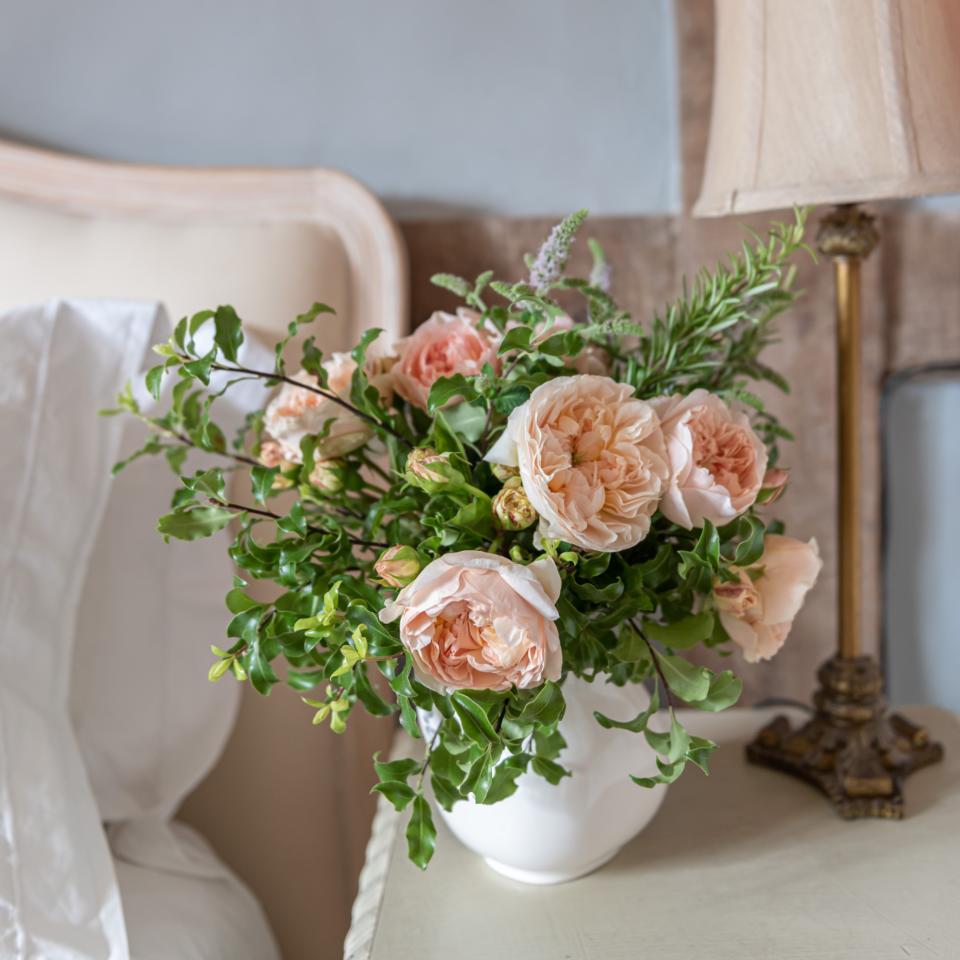 Pink flowers in white vase on table