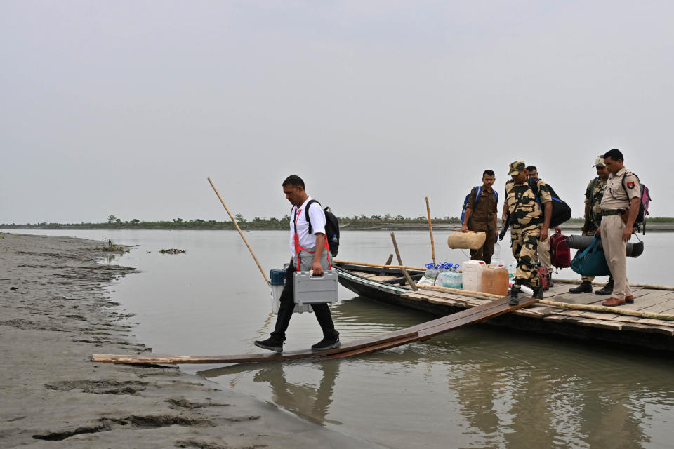 An election official carrying an Electronic Voting Machine (EVM) for a polling station disembarks a boat at Lohore Chapori in Golaghat district, in India's Assam state, April 18, 2024, on the eve of the first phase of India's general election. / Credit: BIJU BORO/AFP/Getty