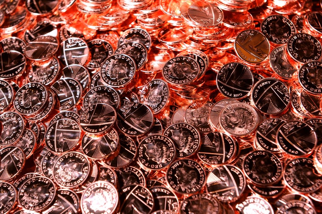 Shiny new pennies come off the production line at the Royal Mint in Pontyclun, Wales (PA)
